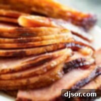 Sweet & Sticky Brown Sugar Ham 2 sliced baked ham with ham glaze on a serving dish