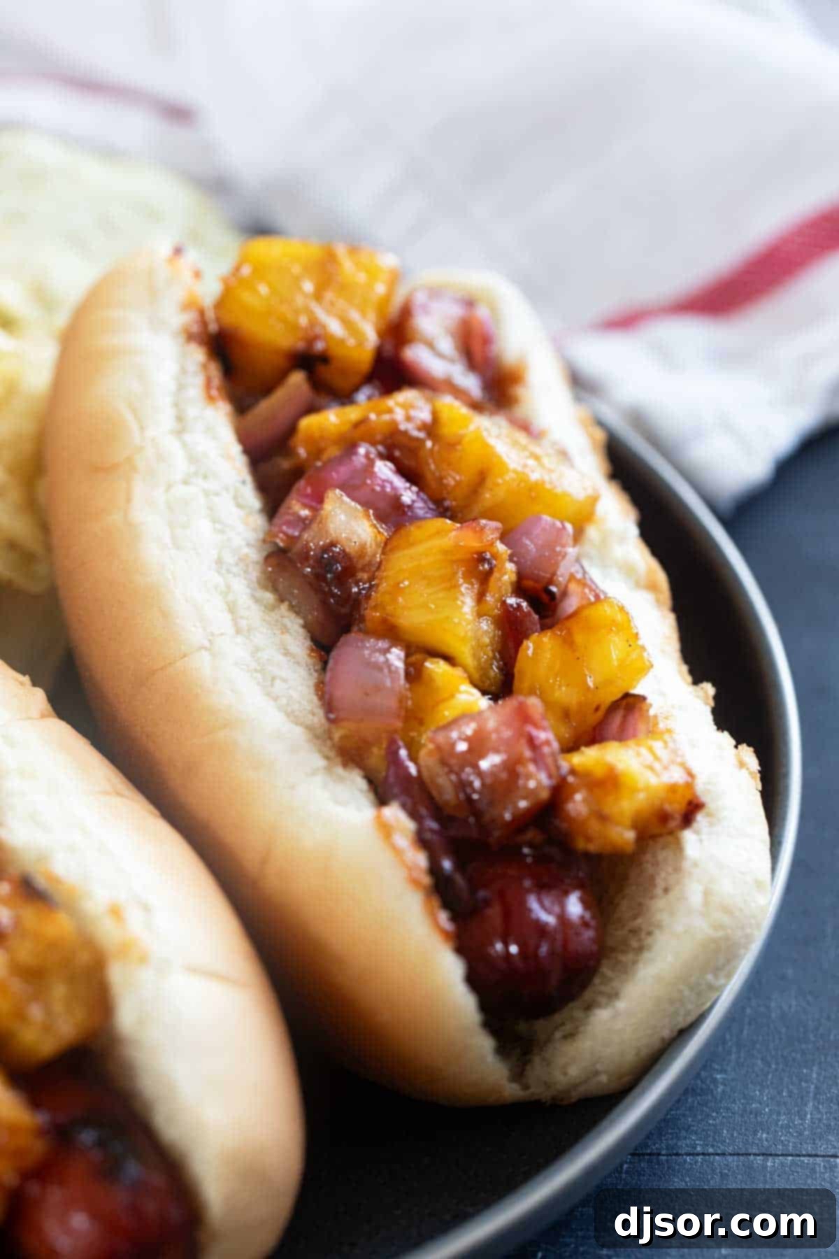 Pineapple Paradise Dogs 2 Hawaiian Hot Dogs with grilled pineapple and red onion with barbecue sauce.