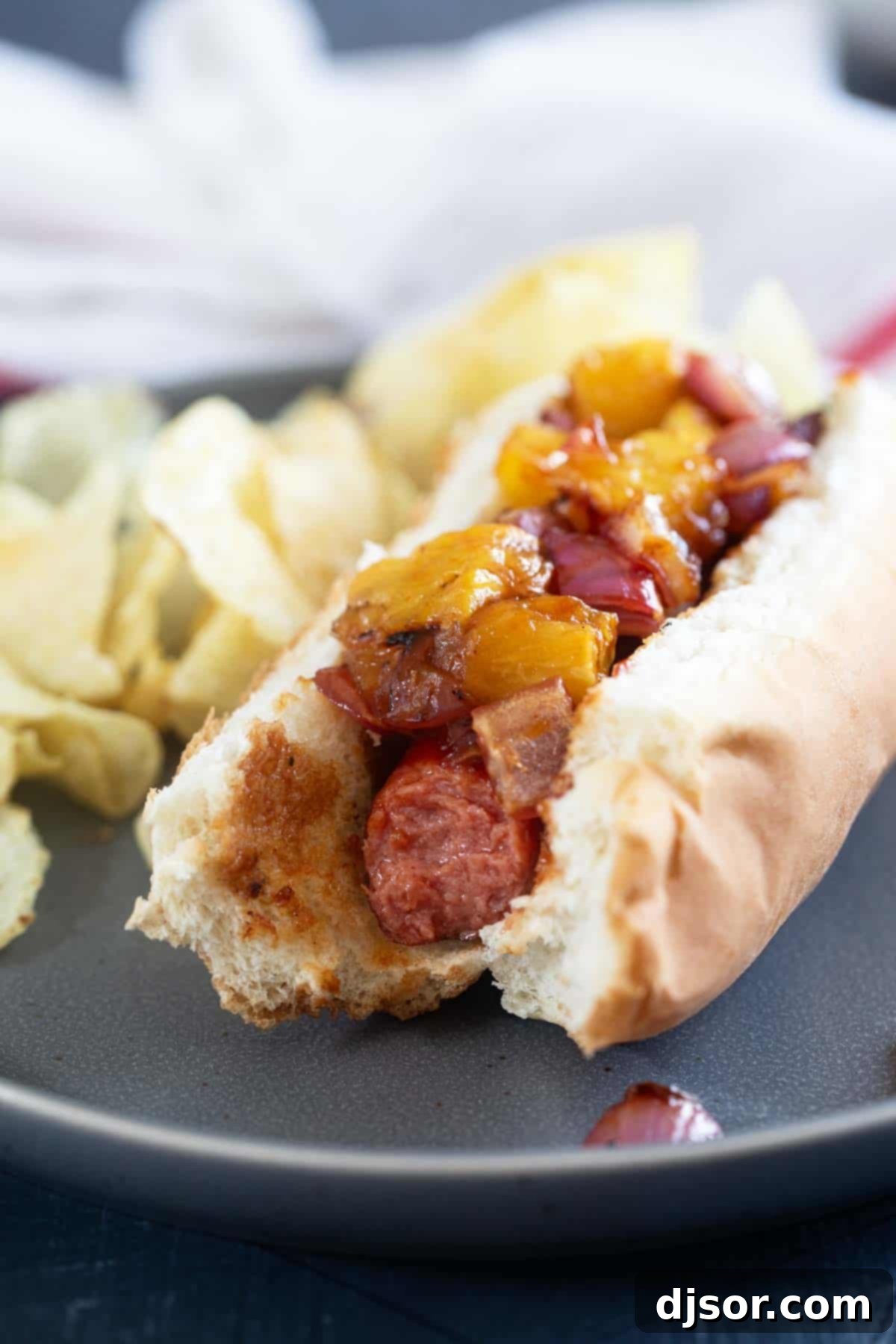 Pineapple Paradise Dogs 8 A Hawaiian Hot Dog with a bite taken out, showing the delicious layers of flavor.