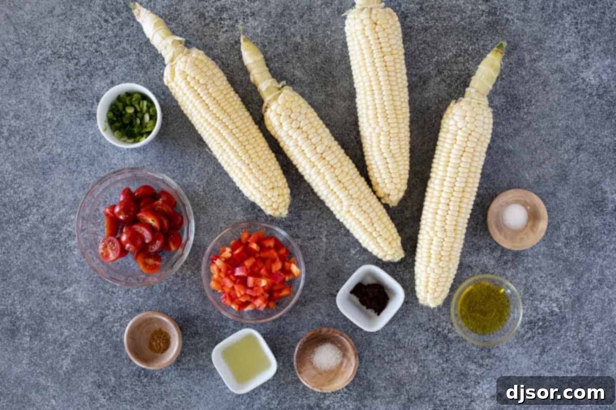 Fresh ingredients for Grilled Corn Salad are neatly arranged on a counter, including ears of corn, red bell pepper, cherry tomatoes, green onions, and various dressing components.