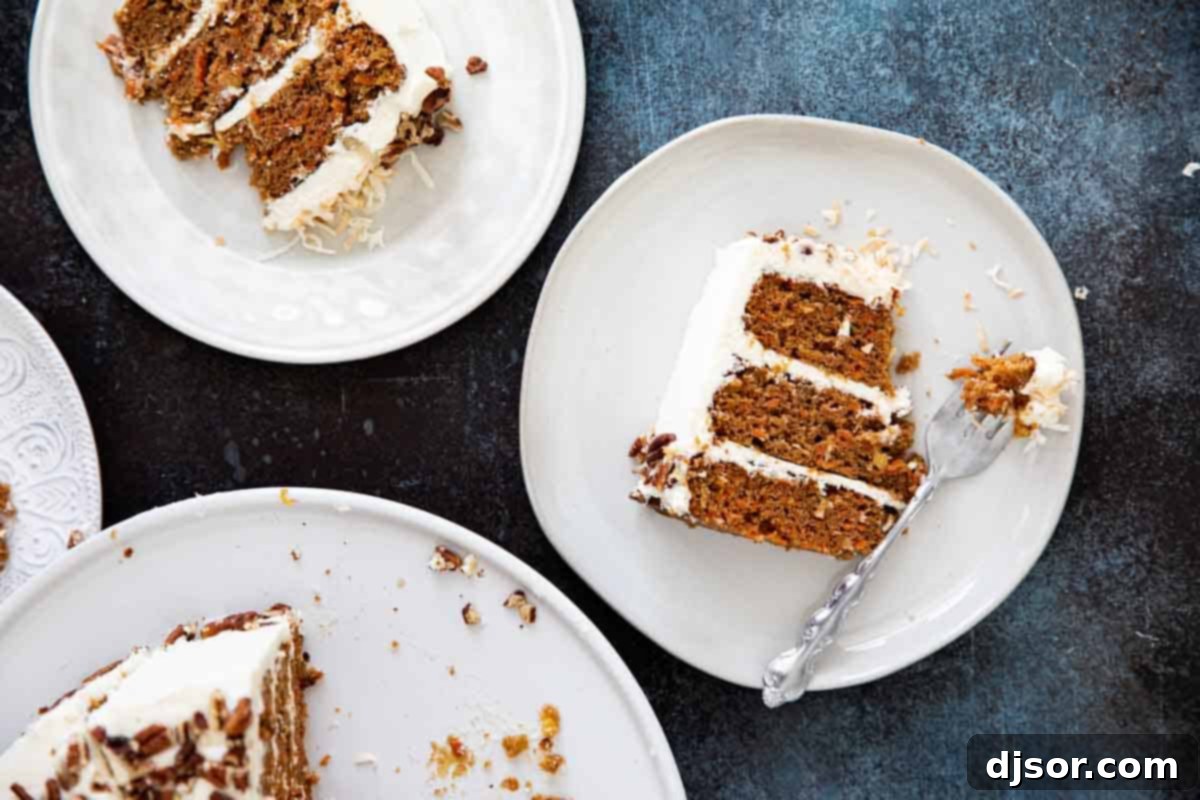 An overhead view of two plates, each holding a generous slice of carrot cake with cream cheese frosting, suggesting a delightful serving presentation.