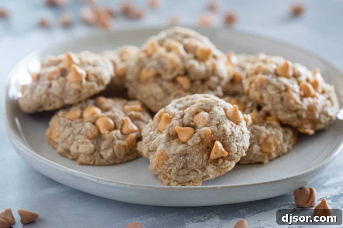 Plate filled with golden brown, soft, and chewy Oatmeal Scotchies cookies, featuring visible oats and melted butterscotch chips.