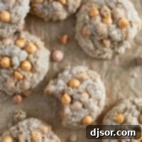 Oatmeal Scotchies on parchment paper with a bite taken from one.