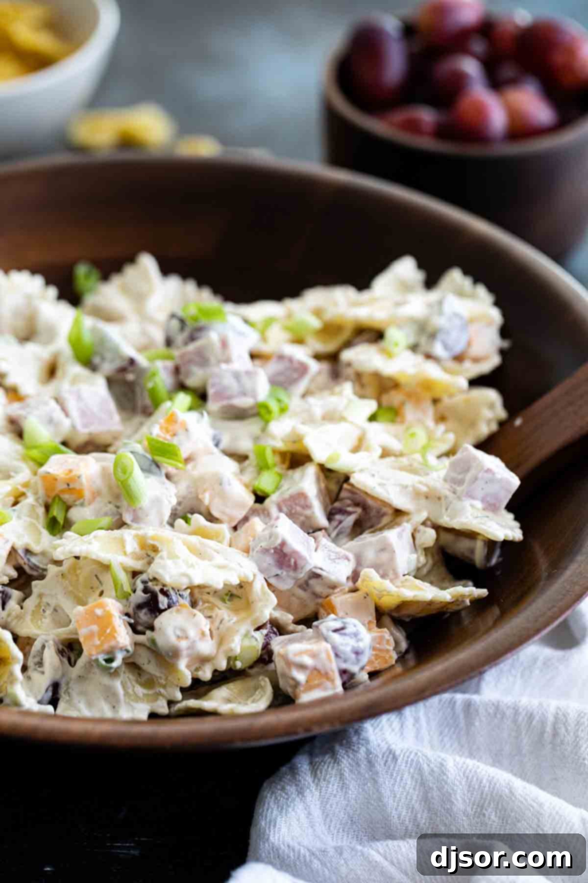 bowl with pasta salad with ingredients in the back