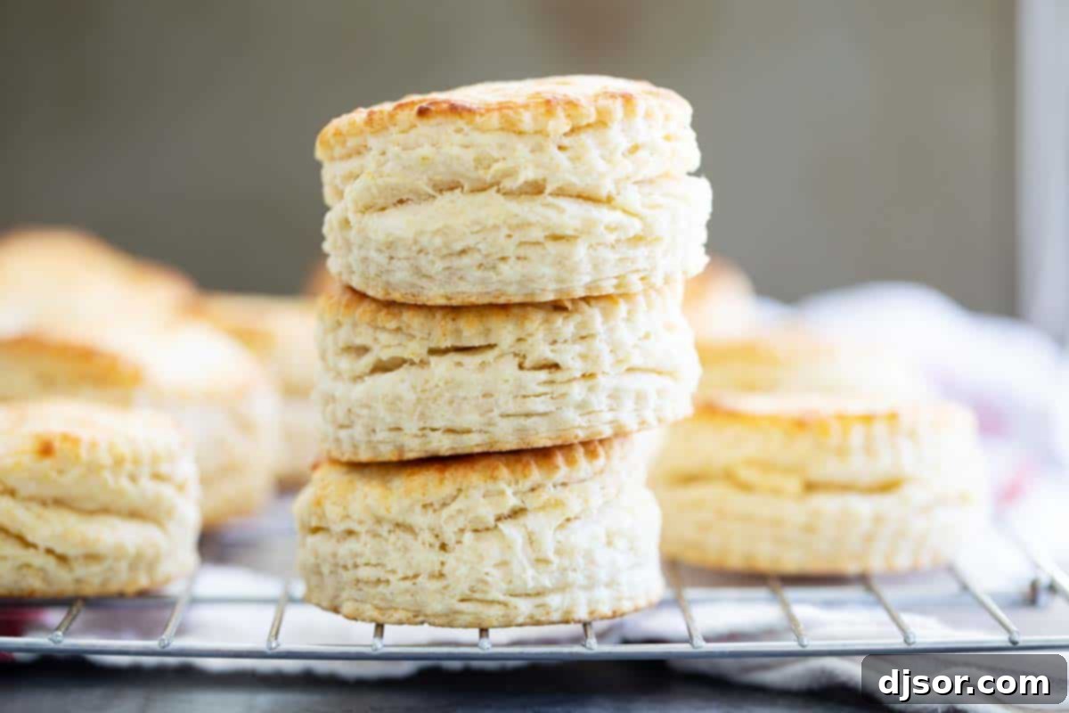 Stack of golden-brown homemade buttermilk biscuits with visible flaky layers