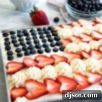 American flag cake topped with buttercream, strawberries and blueberries