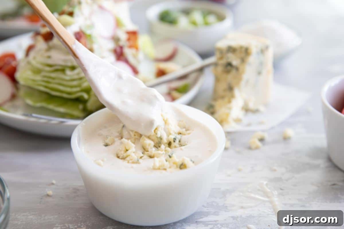 Tangy and creamy, this blue cheese dressing is better than bottled! Use it on a salad, serve it to dip with wings, or as a vegetable dipper. taking a spoonful of blue cheese dressing from a small bowl