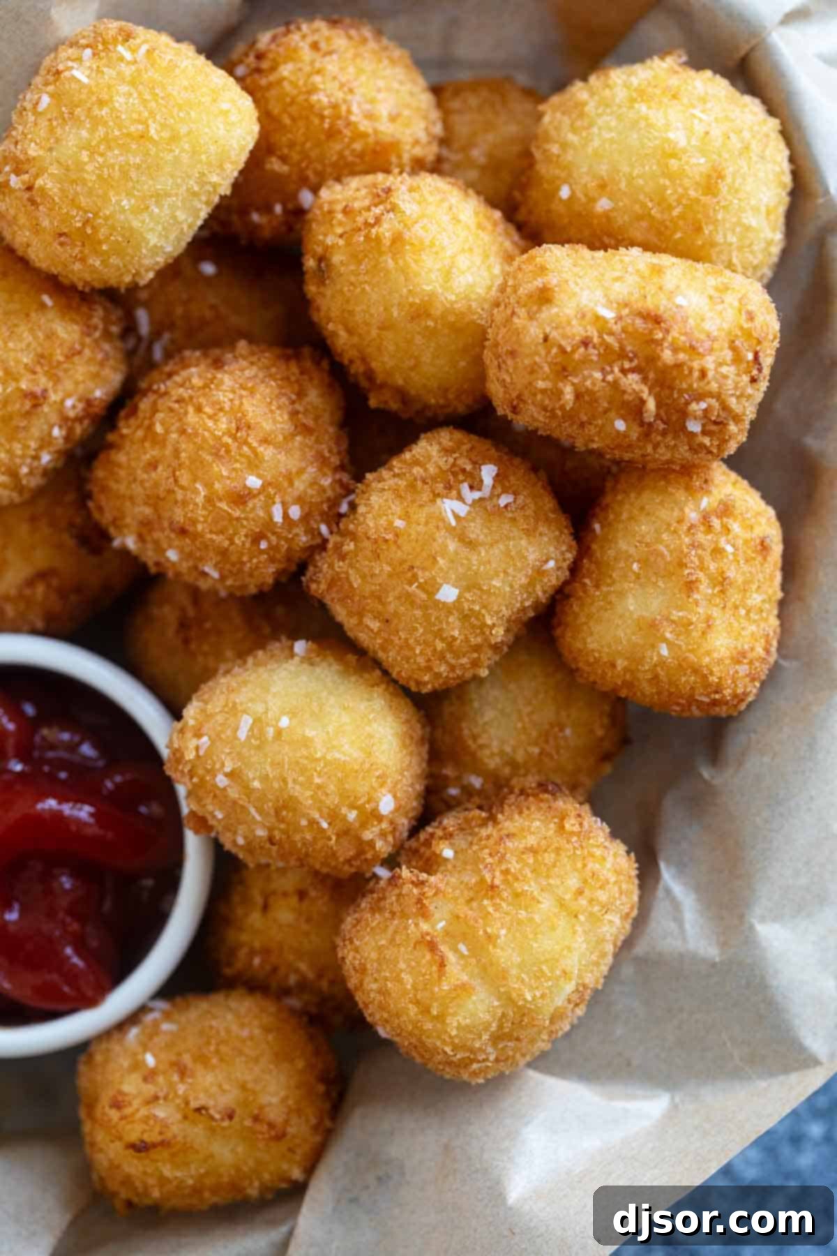 A charming basket filled to the brim with crispy, golden homemade tater tots, with a side of ketchup for dipping.