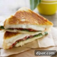 Ultimate Three Cheese Grilled Sandwich with Tomato 2 sliced grilled cheese sandwich with tomatoes and basil