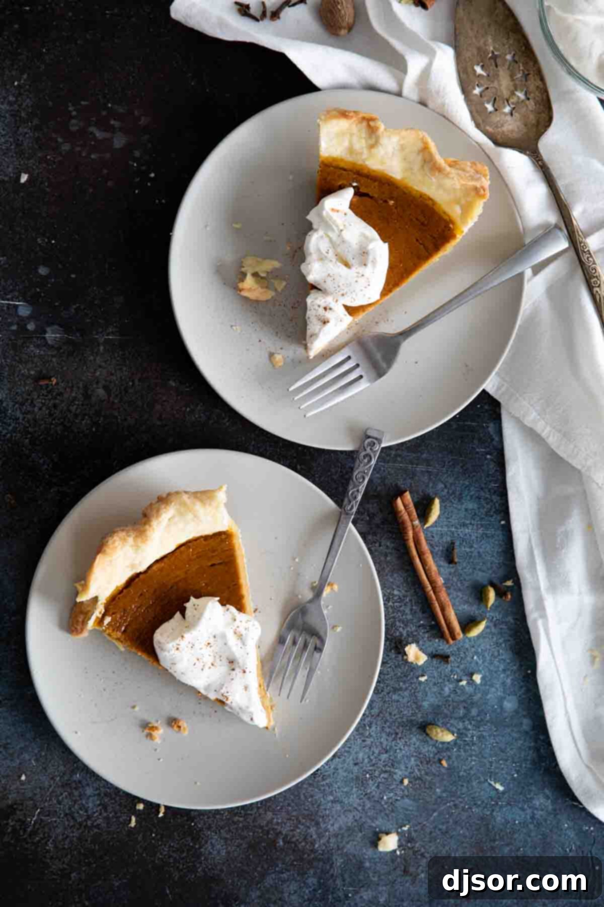 A traditional holiday pie, this classic Pumpkin Pie is filled with warm spices and is super easy to prepare. This pie is smooth and creamy and delicious! overhead view of 2 slices of pumpkin pie