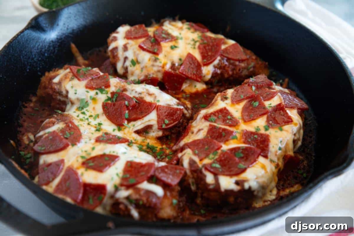 Crispy Chicken Pepperoni topped with melted cheese and vibrant pepperoni in a cast iron skillet, ready to serve.