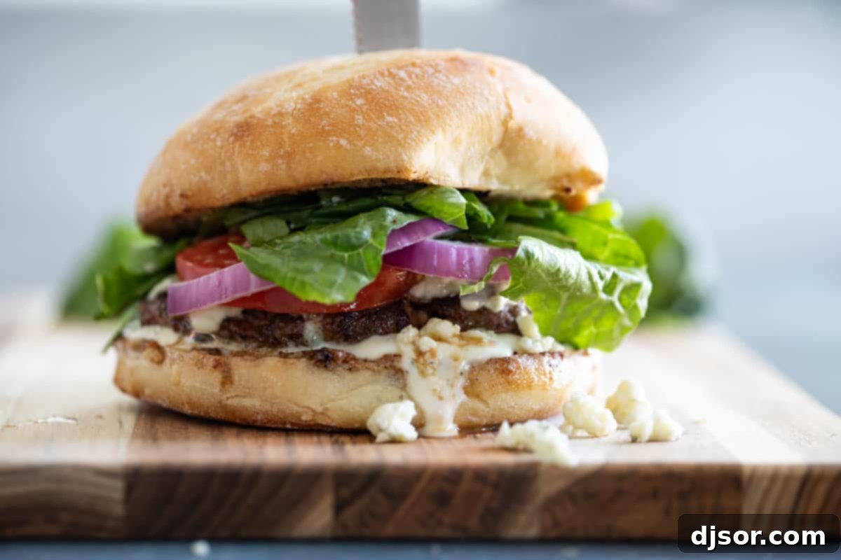 Nothing beats a juicy burger - especially when it’s topped with blue cheese! These Blue Cheese Burgers are simple yet filled with flavor. Blue Cheese Burger on a cutting board, ready to be served, showcasing its juicy patty and melted blue cheese.