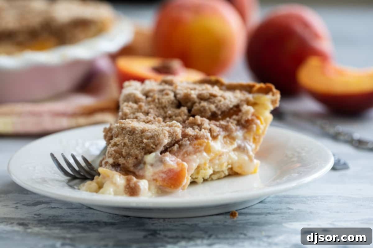 Slice of Sour Cream Peach Pie on a plate with a fork.