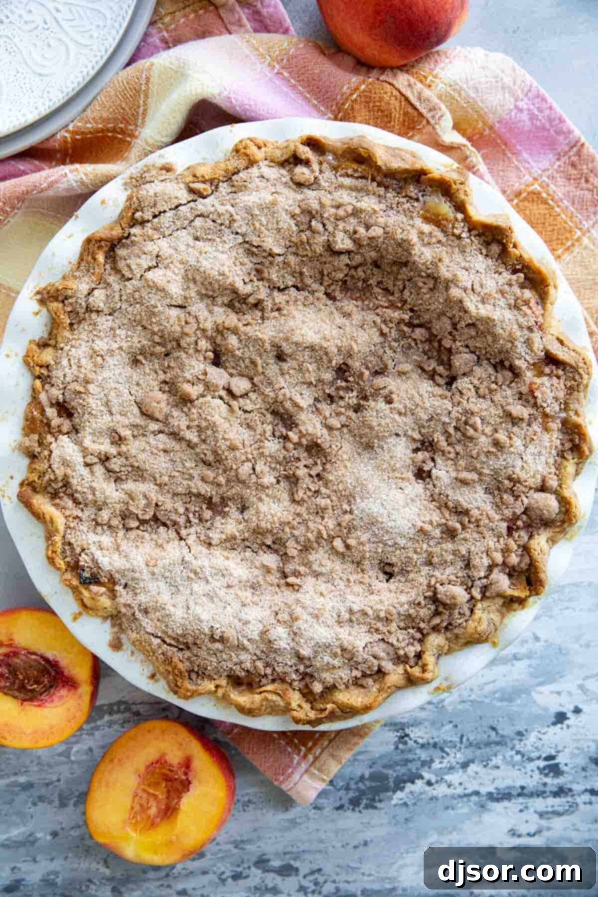 Full sour cream peach pie with a streusel topping.