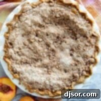 Full sour cream peach pie with a streusel topping.