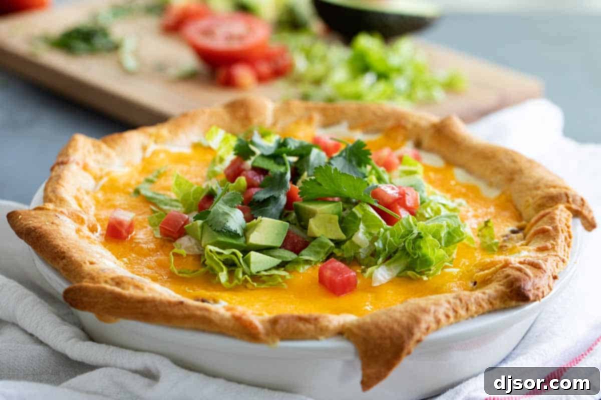Delicious Taco Pie with Crescent Roll Crust whole taco pie made with crescent rolls with toppings on top, ready to serve for dinner