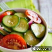 bowl of zucchini salad with tomatoes and red onions