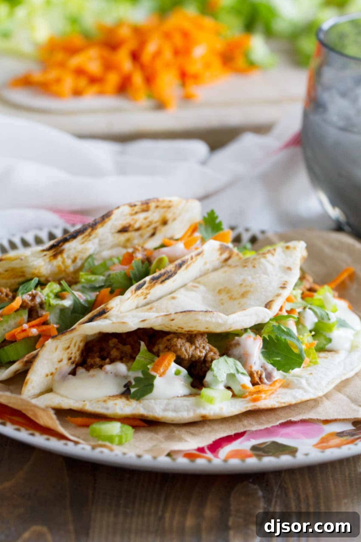 Delicious Buffalo Beef Tacos assembled in flour tortillas, garnished with lettuce and blue cheese dressing.