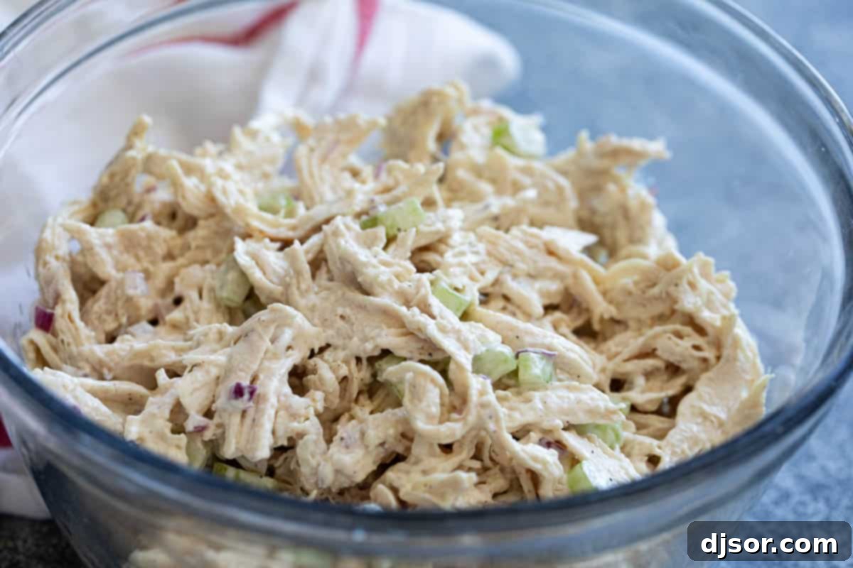 Classic chicken salad with shredded chicken in a bowl, ready to be served.