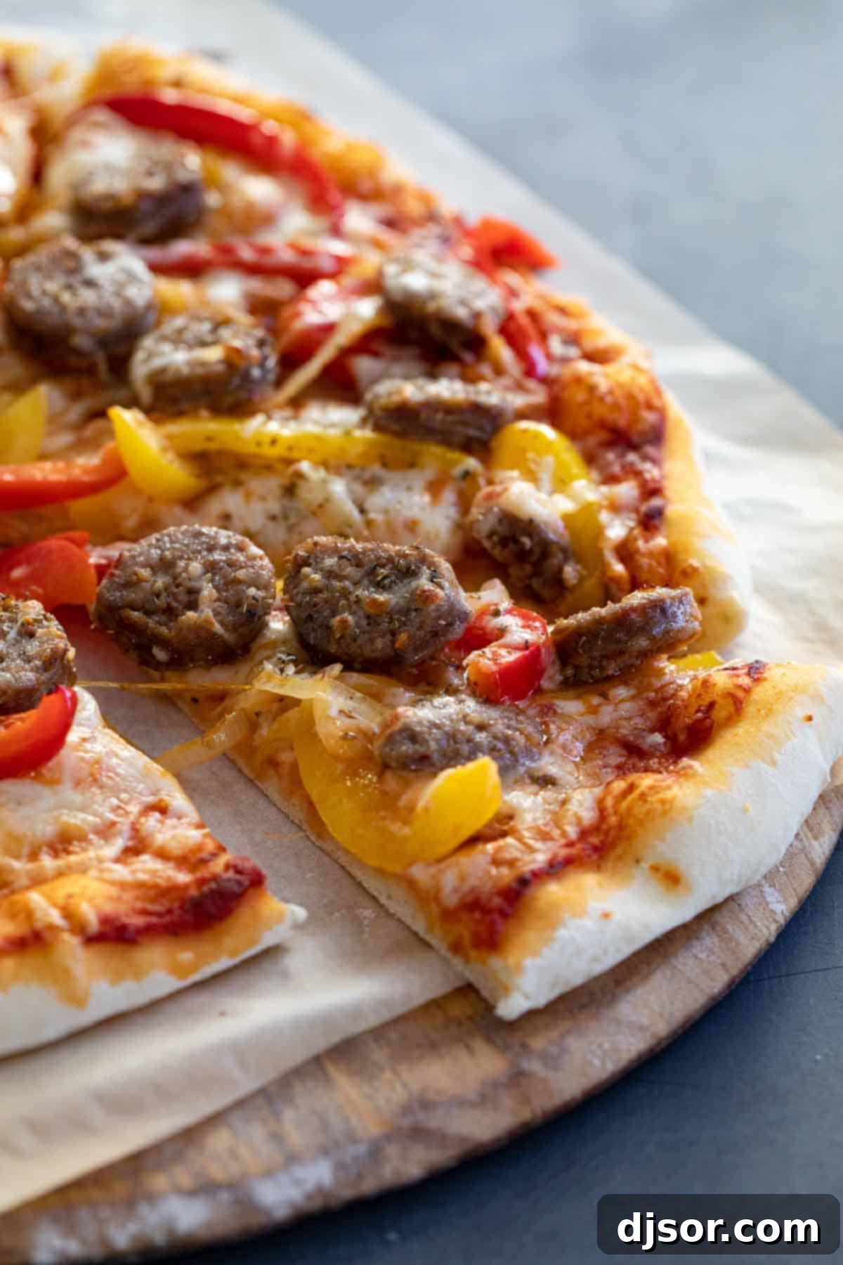 Delicious Slice of Sausage and Peppers Pizza A single slice of Sausage and Peppers Pizza, showing the perfectly browned crust, melted cheese, and colorful toppings.