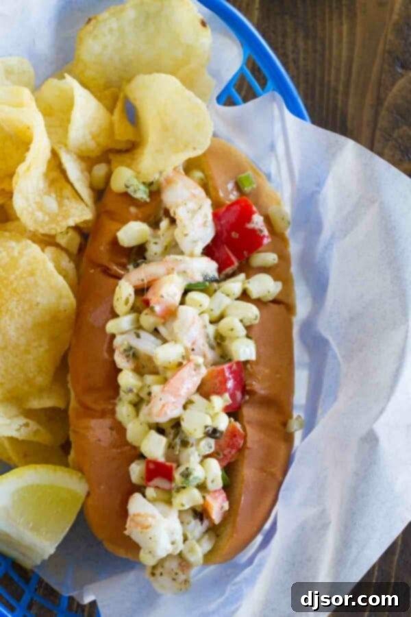 Two shrimp rolls bursting with a colorful mixture of shrimp, corn, red bell peppers, and green onions, served alongside a pile of golden potato chips.