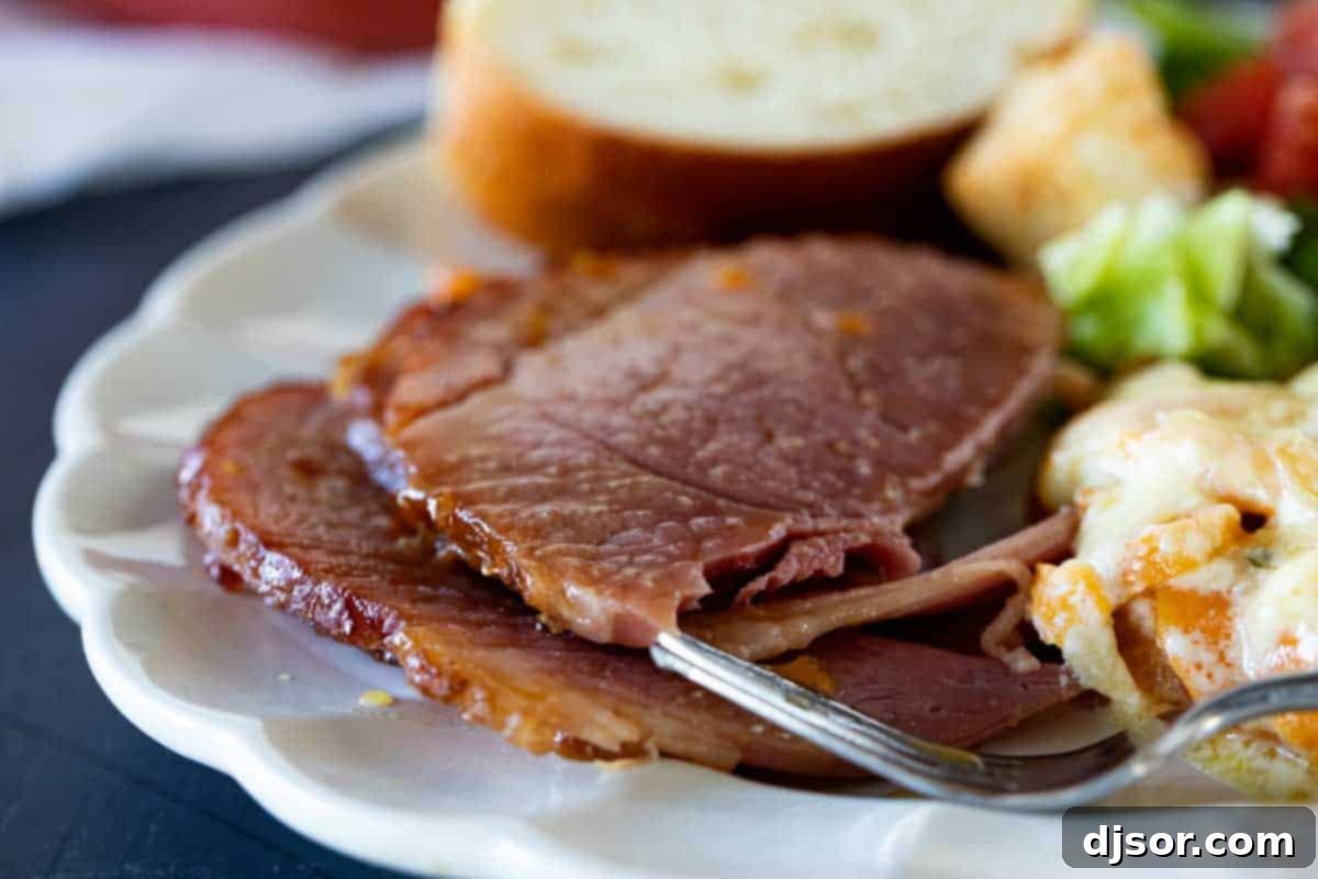 The perfect holiday meal, complete with Crock Pot Ham. A complete holiday plate featuring delicious Crock Pot Ham, creamy scalloped potatoes, fresh bread, and a crisp side salad.