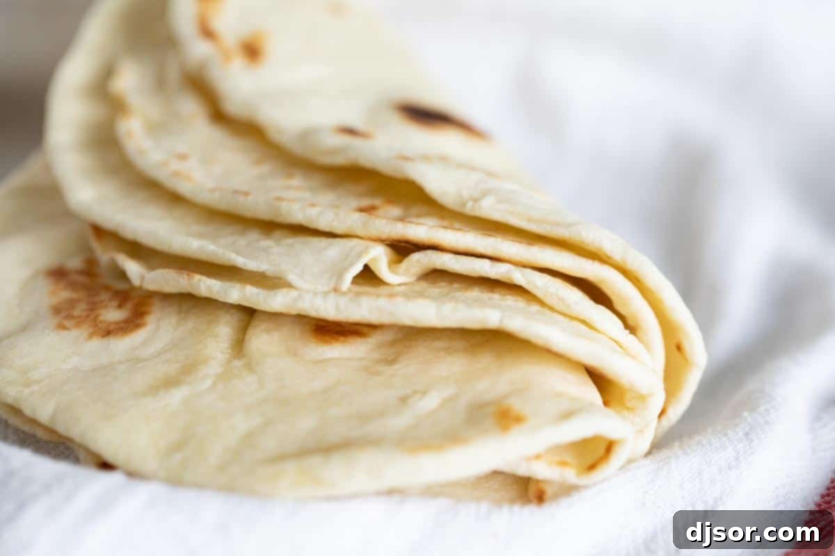 Stack of flour tortillas folded in half, ready to be filled.