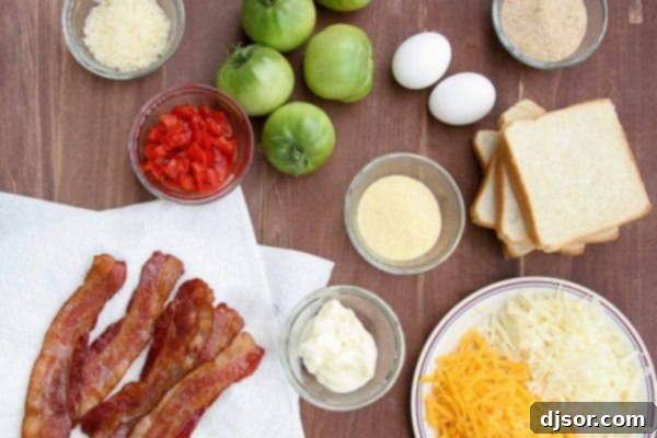 A collection of fresh ingredients laid out for making the ultimate Fried Green Tomato Sandwich: green tomatoes, flour, eggs, breadcrumbs, cornmeal, parmesan cheese, sharp cheddar, monterey jack, mayonnaise, roasted red peppers, bacon, and Texas toast.