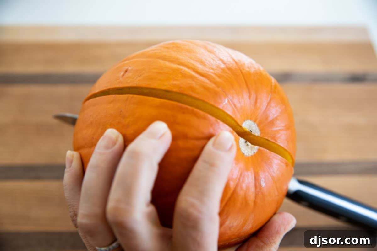 Cutting a sugar pumpkin in half to prepare for making puree
