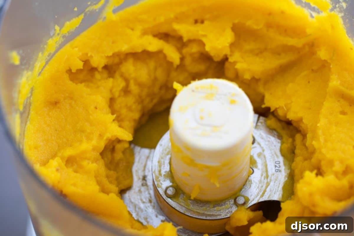 Smooth, golden homemade pumpkin puree in a food processor