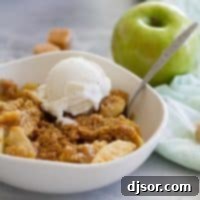 Caramel Apple Crisp in a bowl topped with ice cream.