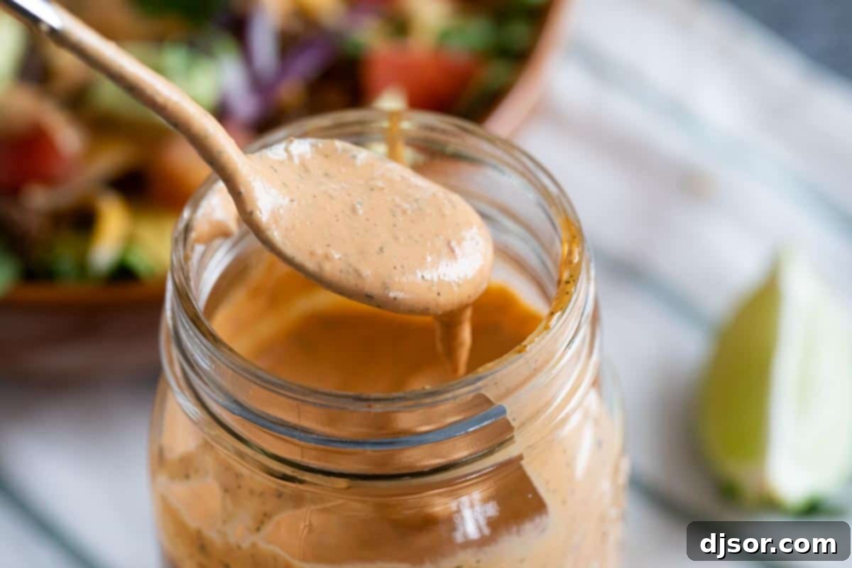 Homemade Chipotle Ranch Dressing Jar of homemade Chipotle Ranch Dressing with a spoon, ready to be served on a vibrant salad or as a dip.