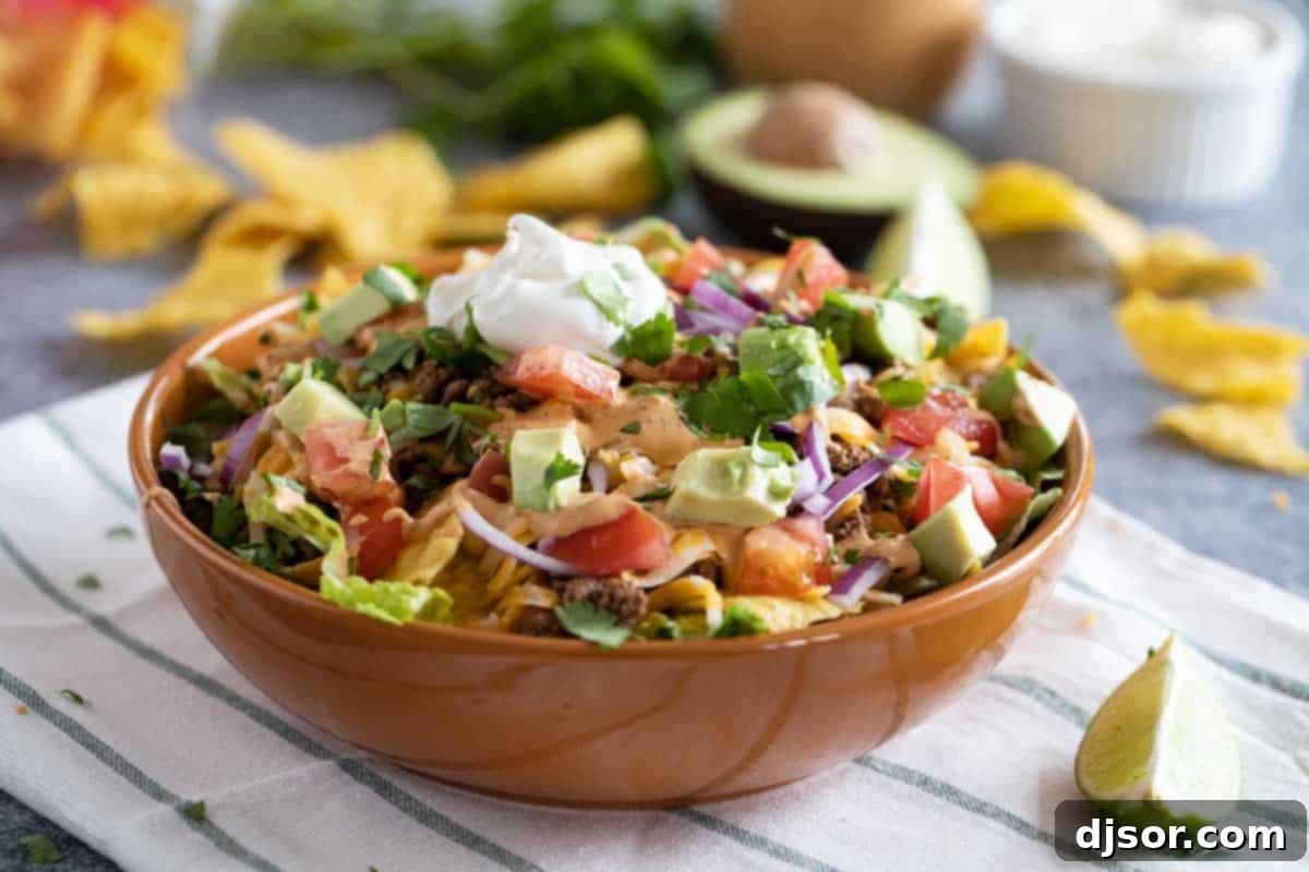 All of your favorite taco flavors, in salad form! This Taco Salad is a taco lovers favorite, and it an easy weeknight meal. It’s also great to set out buffet style so everyone can top their salad with their own favorites! bowl filled with taco salad with lots of toppings