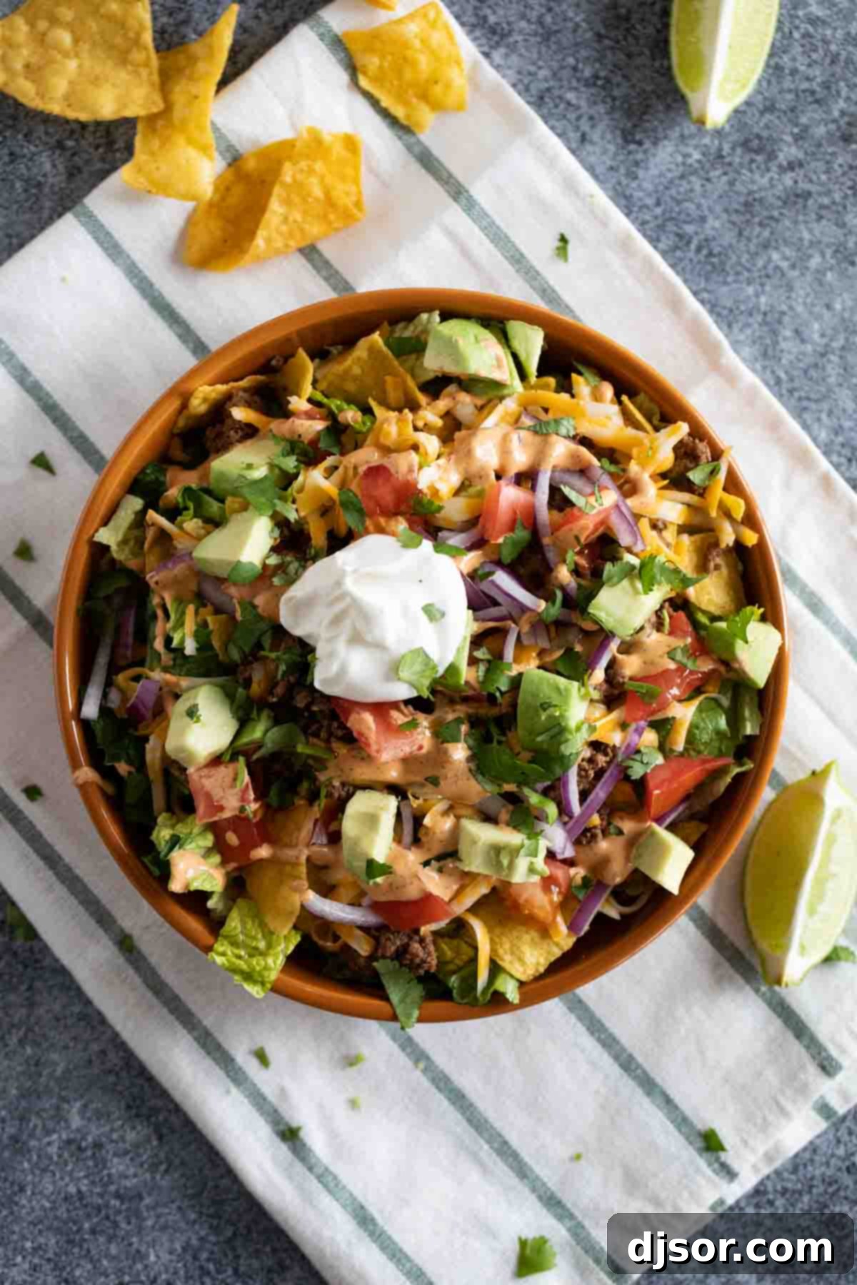 All of your favorite taco flavors, in salad form! This Taco Salad is a taco lovers favorite, and it an easy weeknight meal. It’s also great to set out buffet style so everyone can top their salad with their own favorites! Taco Salad topped with lots of toppings and tortilla chips