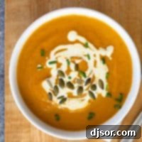 overhead view of a bowl of pumpkin soup on a cutting board