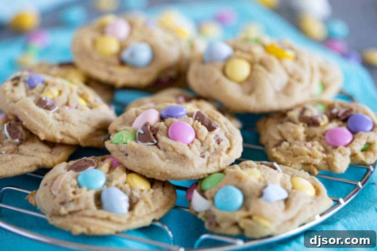 A super soft cookie filled with lots of Easter candy, these Easter Cookies are perfect the weeks leading up to Easter! The pastel colors scream spring, and the flavor and texture will have you coming back for more. Easter cookies stacked on a cooling rack