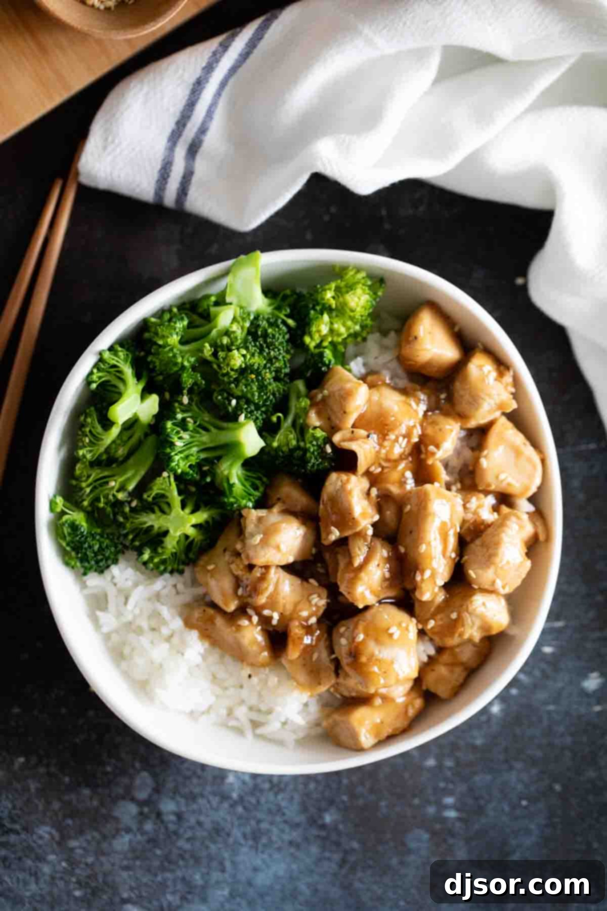 An easy and tasty weeknight meal, these Teriyaki Chicken Bowls are on the table in no time at all and are great for those nights that you don’t feel like cooking. A close-up of a Teriyaki Chicken Bowl, featuring glossy chicken, bright green broccoli, and fluffy white rice, ready to eat.