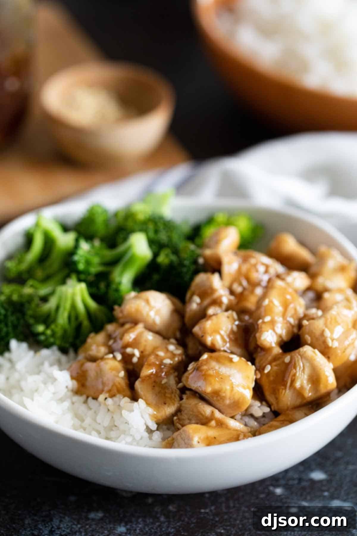 An easy and tasty weeknight meal, these Teriyaki Chicken Bowls are on the table in no time at all and are great for those nights that you don’t feel like cooking. A beautifully presented Teriyaki Chicken Bowl, showcasing the easy and satisfying nature of this weeknight dinner with rice and broccoli.