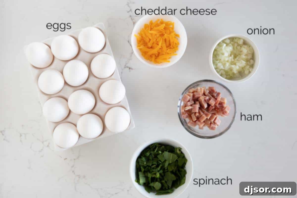 A great make ahead or breakfast on the go, these Egg Muffins and super simple, and super versatile! A selection of fresh ingredients laid out, including eggs, spinach, onion, ham, and cheese, ready for making delicious Egg Muffins.