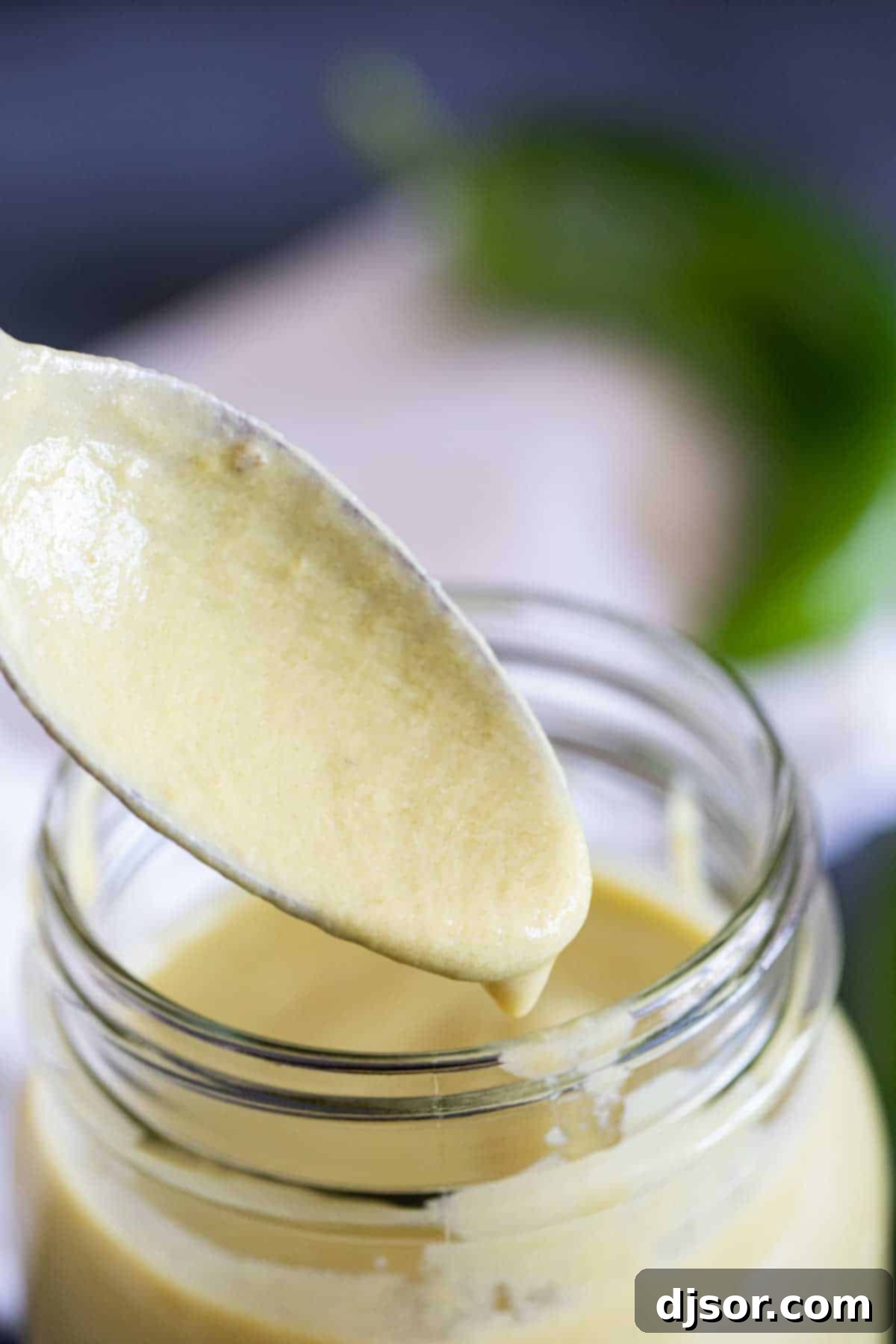 Verde Enchilada Sauce 7 Close-up of a spoon lifting a generous dollop of creamy green enchilada sauce.