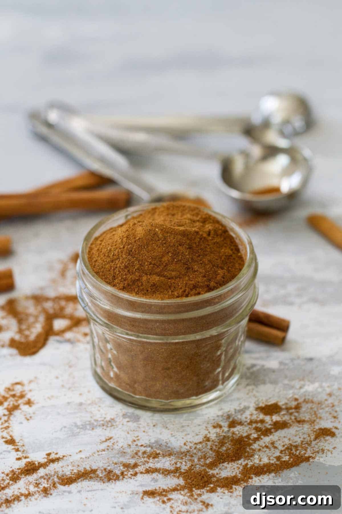 Homemade Pumpkin Pie Spice stored in a small glass jar with a label.
