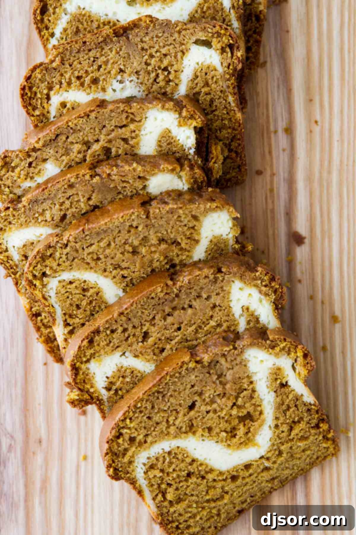 Cream Cheese Pumpkin Bread sliced on a cutting board, revealing the creamy filling.