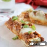 Cheesy Lasagna Pizza Bread 2 Slices of Lasagna Bread Pizza on a wooden cutting board, ready to be served.