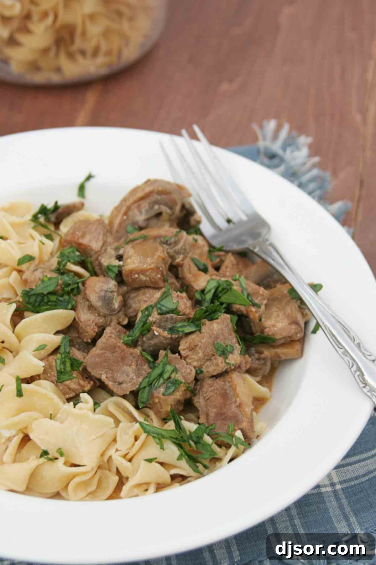 Hearty Slow Cooker Beef Stroganoff with egg noodles and fresh parsley garnish