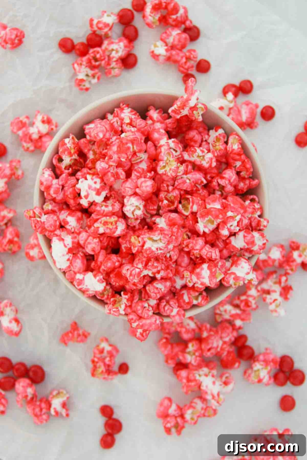 Red Hot Popcorn - spice up your popcorn with this easy cinnamon coated popcorn. bowl of Red Hot Popcorn spilling over
