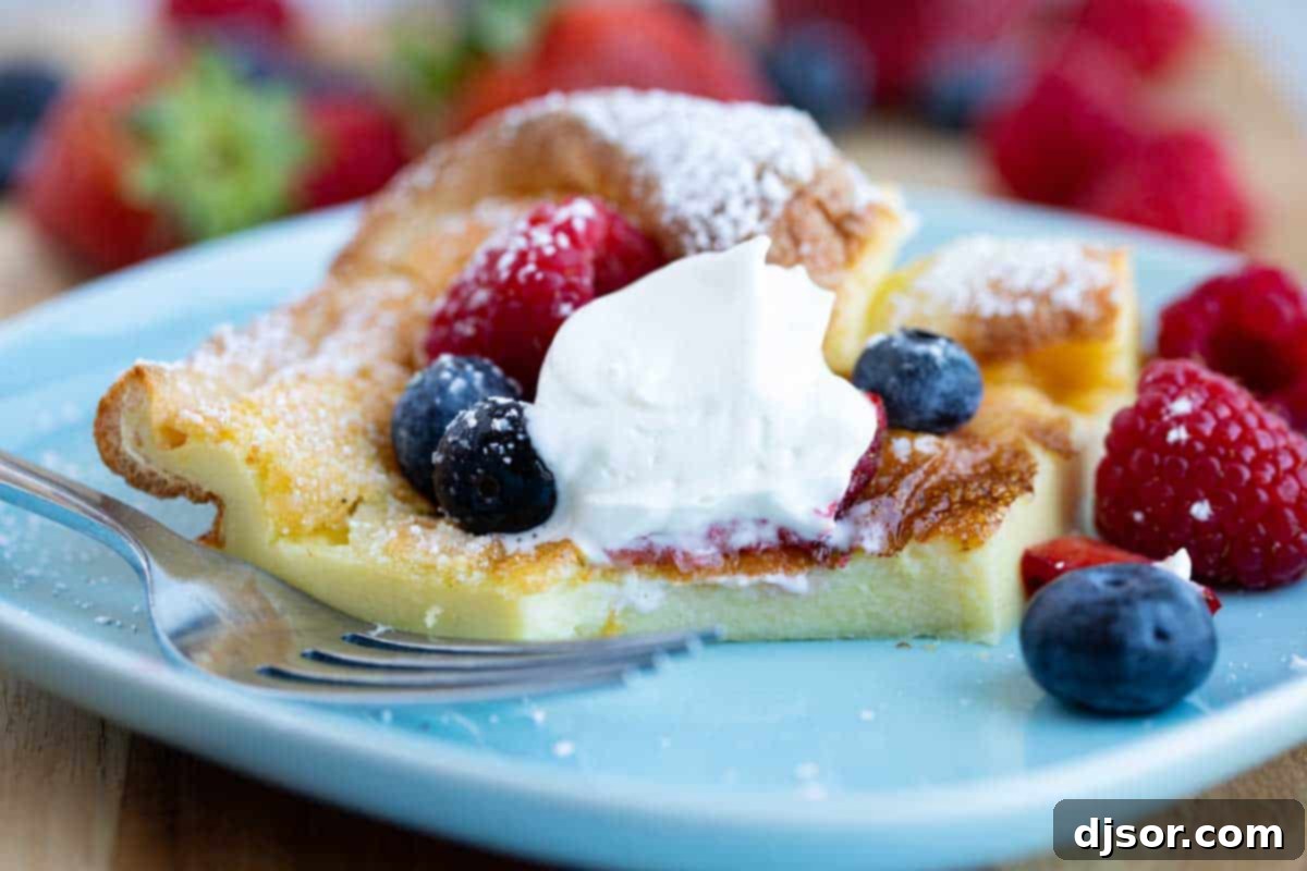 A close-up of a Dutch Baby with a bite taken, showcasing its soft, golden interior and fluffy texture