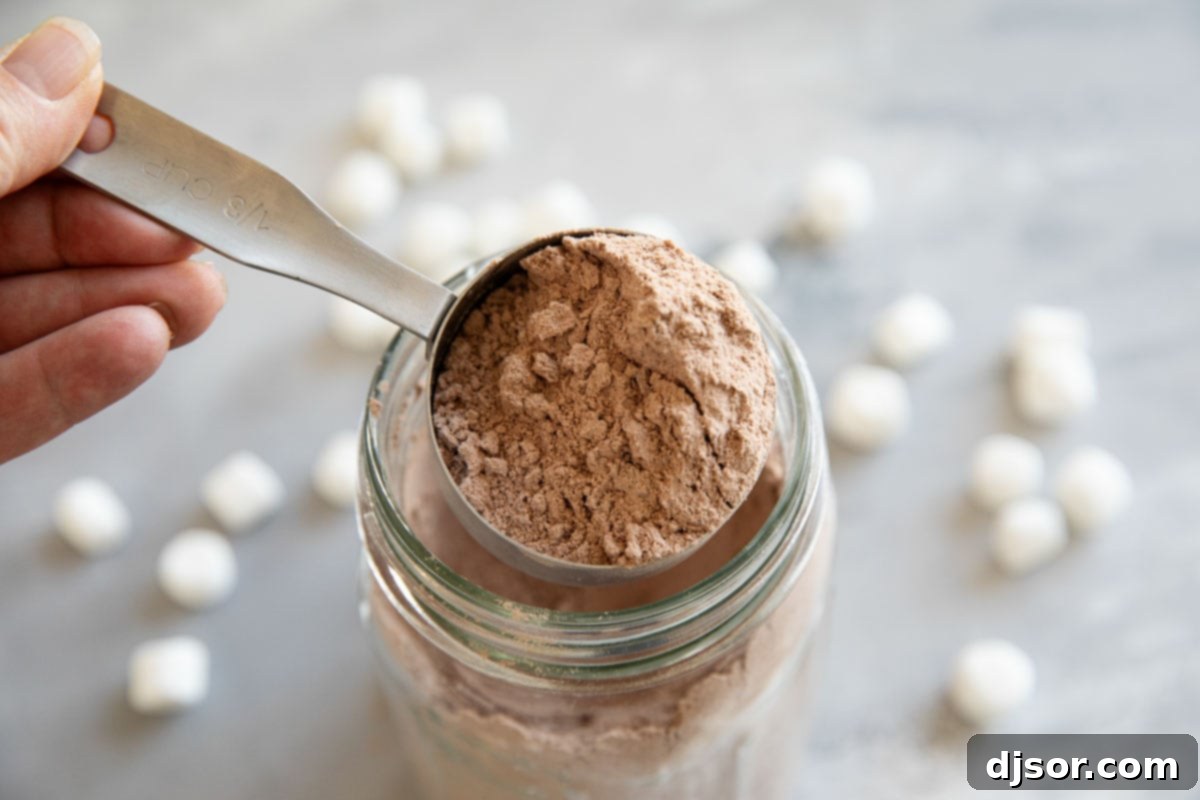 Homemade hot chocolate mix in a jar with a measuring cup.