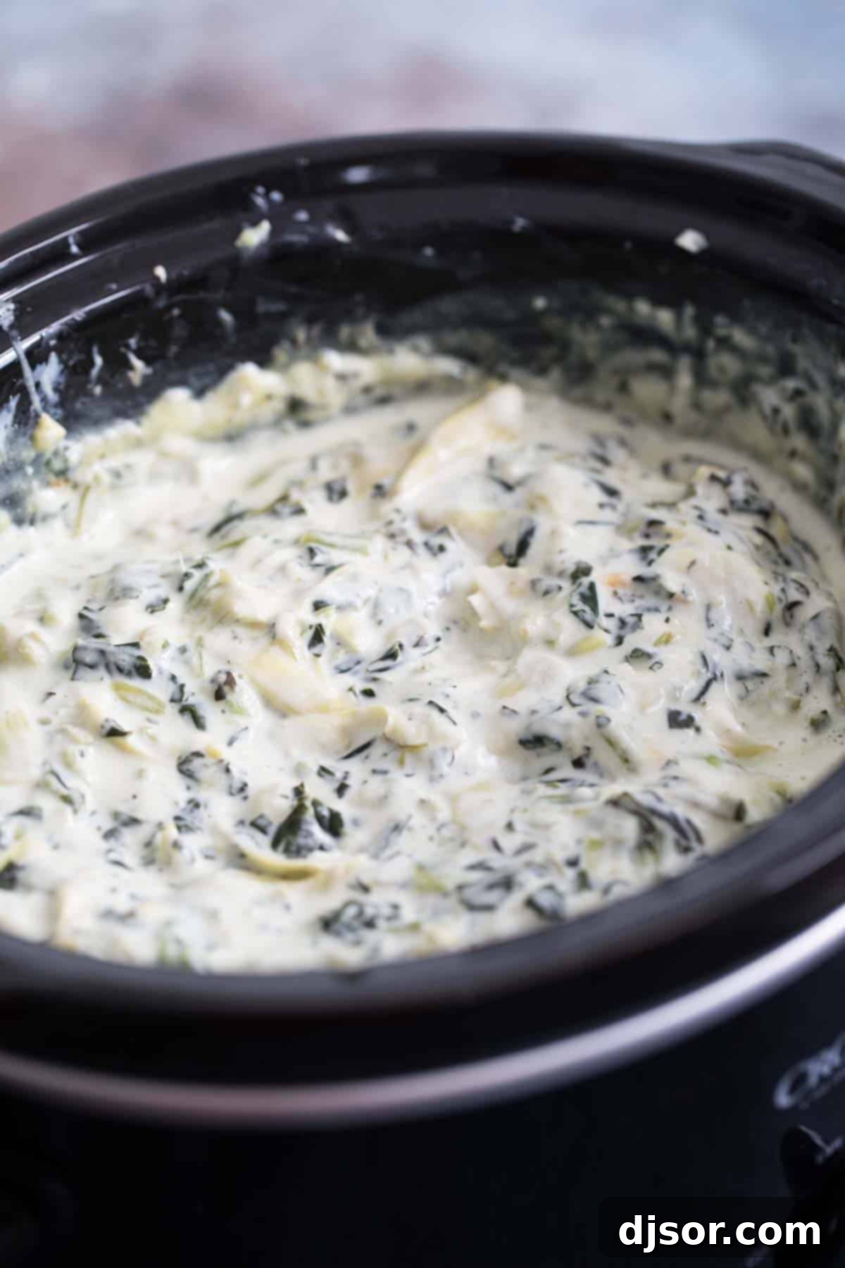 Make it ahead! The best of crockpot appetizers, this Crockpot Spinach Artichoke Dip is a great make ahead appetizer recipe that everyone loves. Only a few ingredients, a few minutes of prep work, and you have a dip that will disappear quickly. crockpot full of spinach artichoke dip