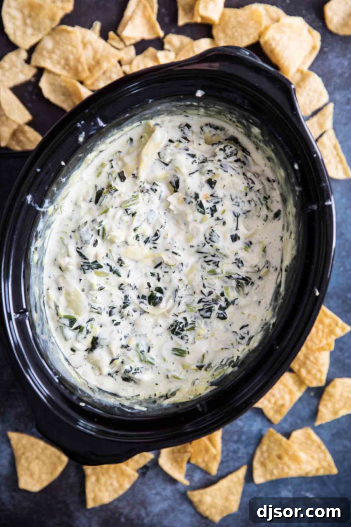 Make it ahead! The best of crockpot appetizers, this Crockpot Spinach Artichoke Dip is a great make ahead appetizer recipe that everyone loves. Only a few ingredients, a few minutes of prep work, and you have a dip that will disappear quickly. Spinach Artichoke Dip in the Slow Cooker surrounded by tortilla chips