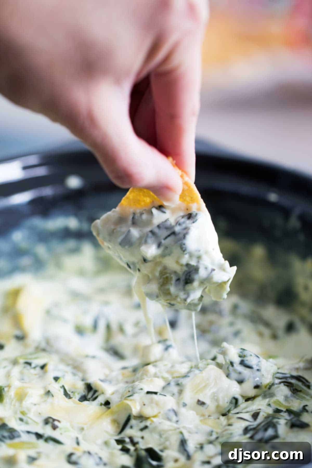 Make it ahead! The best of crockpot appetizers, this Crockpot Spinach Artichoke Dip is a great make ahead appetizer recipe that everyone loves. Only a few ingredients, a few minutes of prep work, and you have a dip that will disappear quickly. Crockpot Spinach Artichoke Dip with a chip dipping in